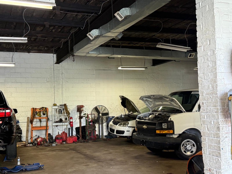 Adentro del taller, con camionetas en reparación